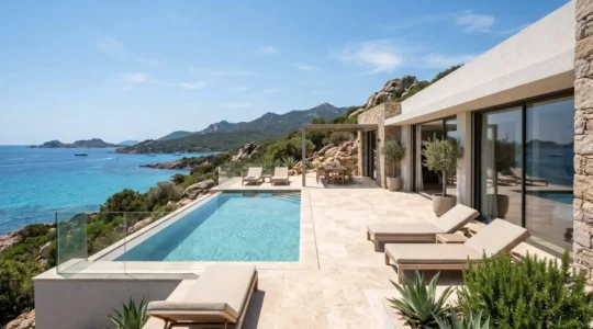 Vue extérieure d'une villa moderne en Corse du Sud avec terrasse aménagée et vue panoramique sur la mer Méditerranée